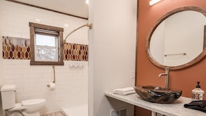 Une salle de bain avec des toilettes, un lavabo et une douche.