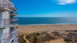 Een hotel aan het strand met meerdere balkons met uitzicht op de oceaan.