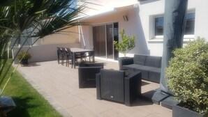 En terrasse med udendørs møbler, et bord og stole.