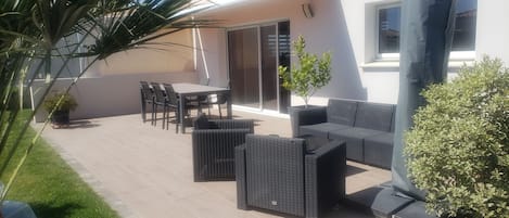 A patio with outdoor furniture, a table, and chairs.