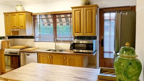 Une cuisine avec des meubles de rangement en bois, un four à micro-ondes, une cuisinière et un réfrigérateur.