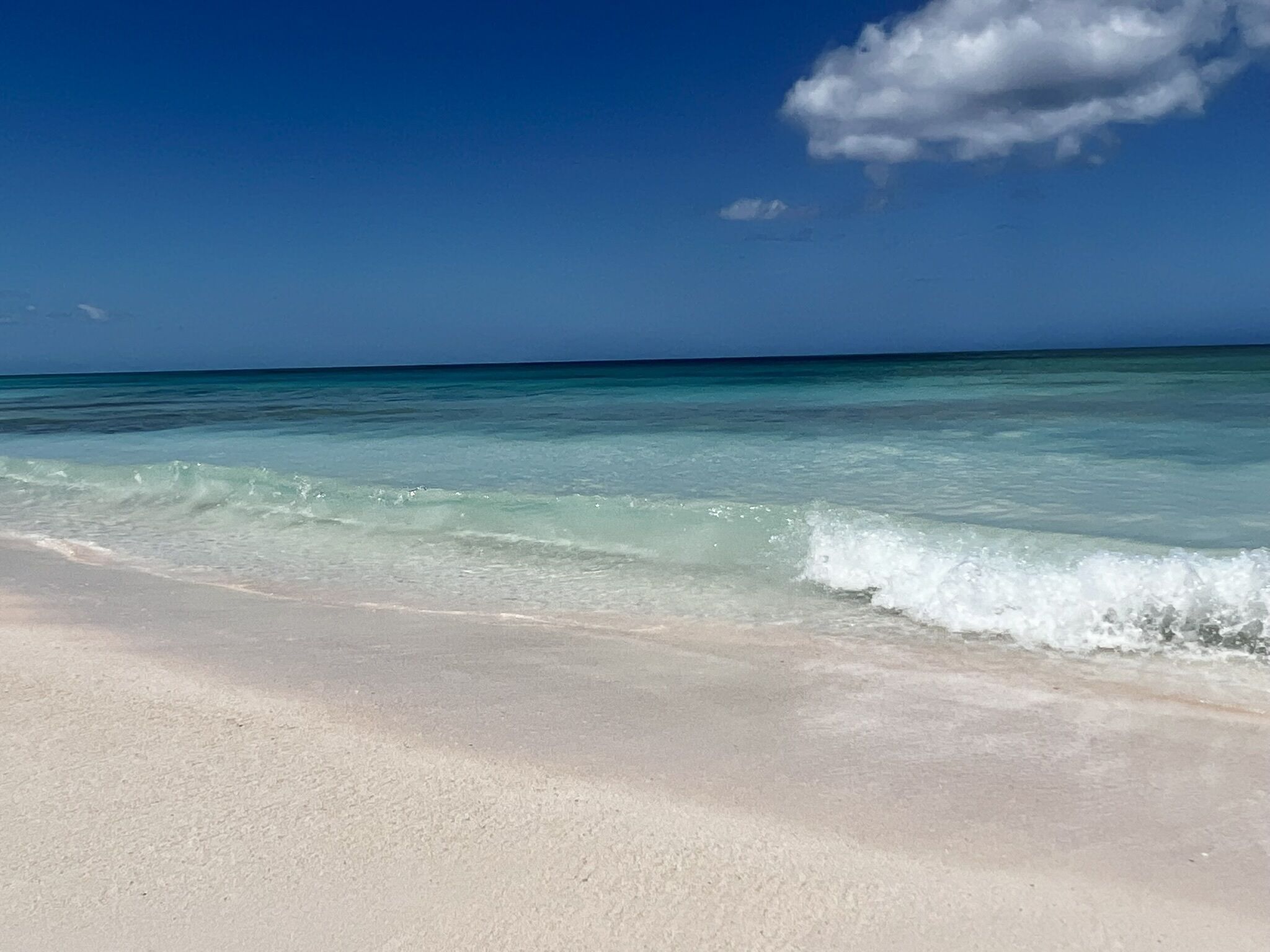 Una spiaggia con acque cristalline turchesi e una riva sabbiosa.