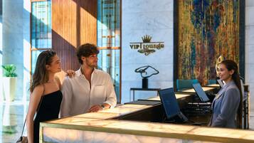 A reception desk with a marble top, a logo for 'VIP Lounge,' and a large abstract painting on the wall.