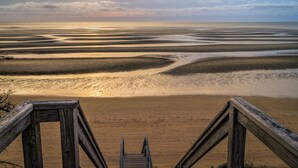 A wooden staircase leading to a sandy beach with a sunset in the background. - 600 Feet to Private Association Cape Cod Bay Beach (2266) (Eastham)