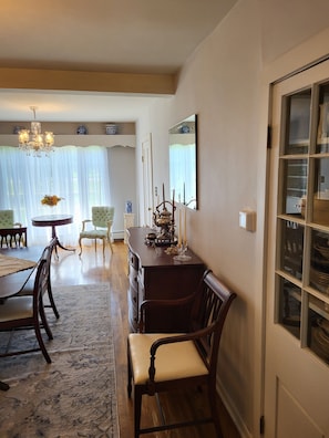 A dining area with a wooden table, chairs, and a chandelier. There is a mirror on the wall and a window with blinds. - Close to snowmobile and atv trails. Minutes from Porcupine mountains. (Ontonagon)