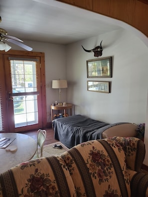 A cozy room with a bed, a chair, a table, a lamp, and a window with blinds. - Close to snowmobile and atv trails. Minutes from Porcupine mountains. (Ontonagon)