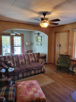 A cozy living room with a wooden ceiling, a ceiling fan, a sofa, a chair, and a rug. - Close to snowmobile and atv trails. Minutes from Porcupine mountains. (Ontonagon)