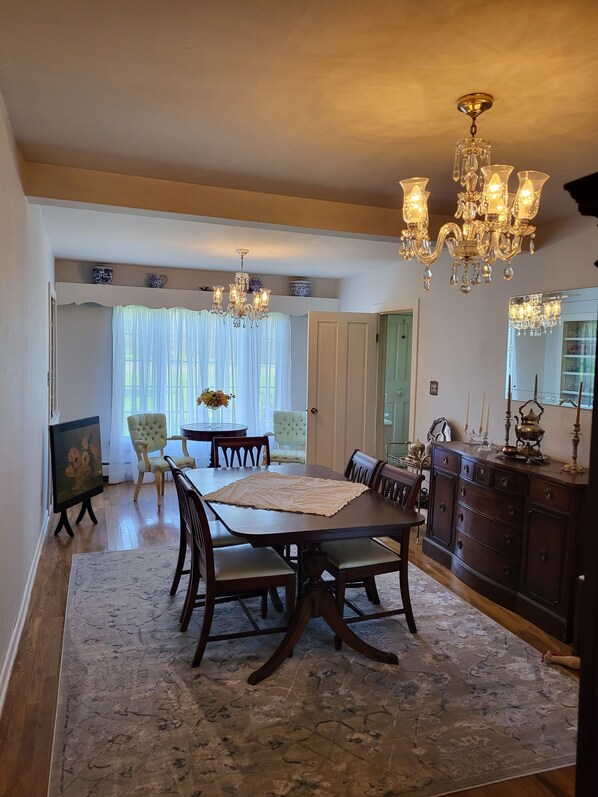 A dining room with a wooden table, chairs, a chandelier, and a large mirror. - Close to snowmobile and atv trails. Minutes from Porcupine mountains. (Ontonagon)