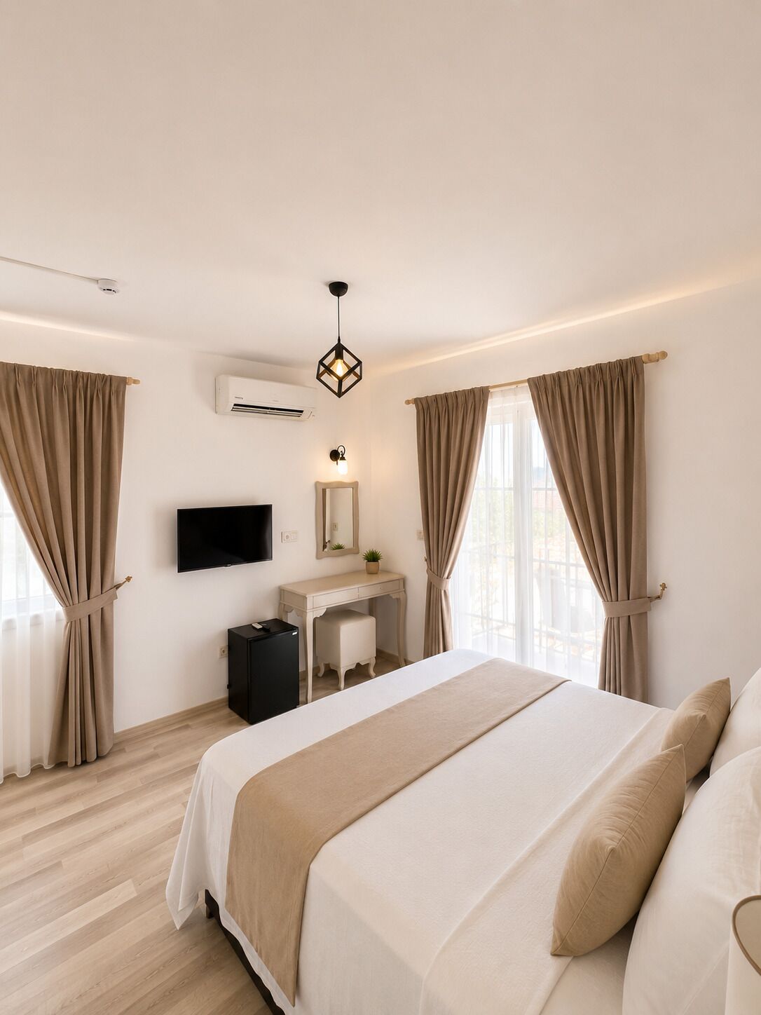 Ein Hotelzimmer mit Bett, Schreibtisch, Fernseher und Klimaanlage.