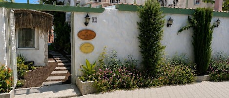 A building with a balcony, a staircase, and a wall with plaques.