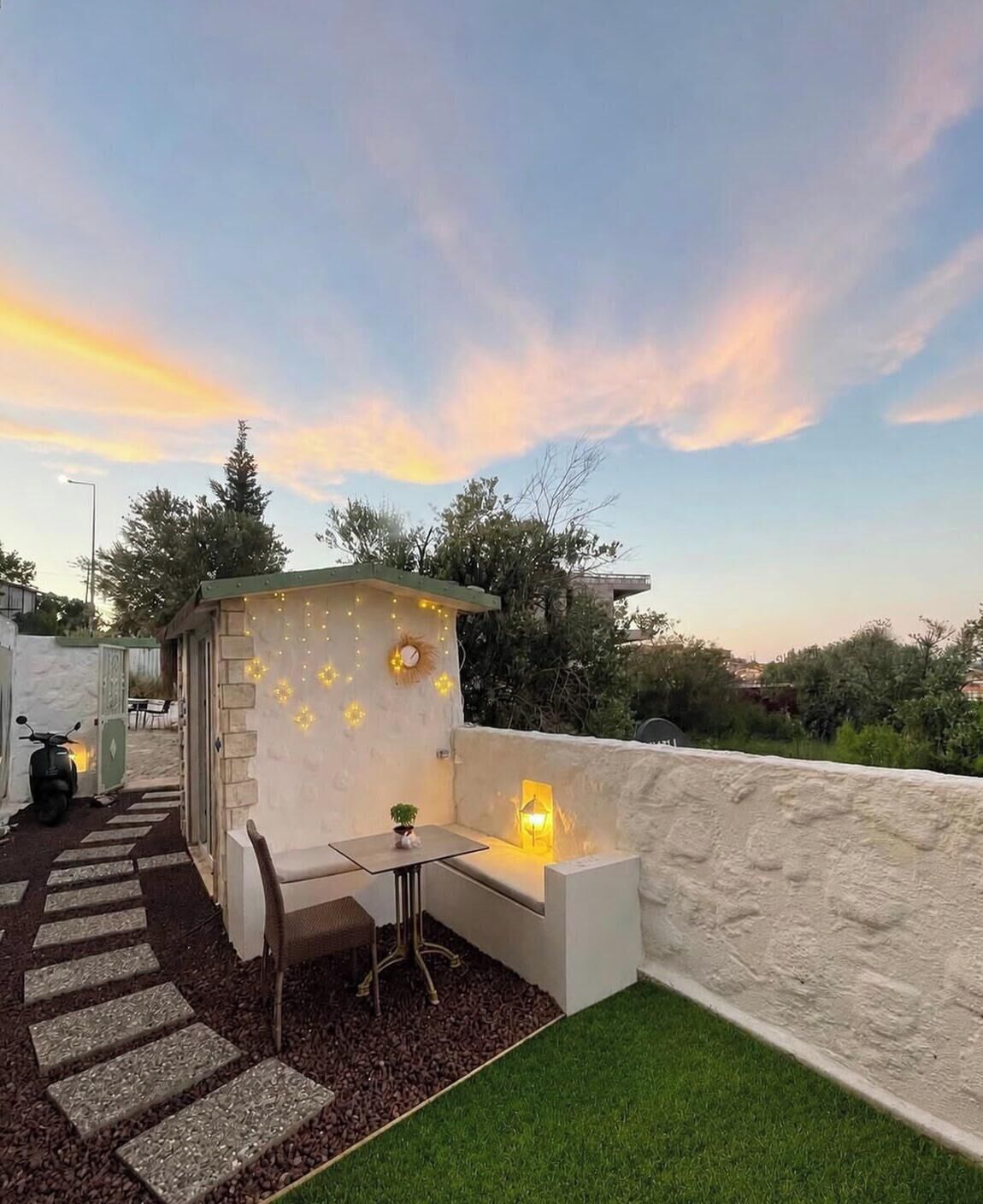 Une terrasse sur le toit, avec un espace salon, une petite table et une lanterne.