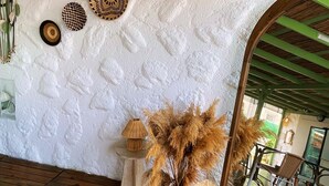 A room with a rustic wooden ceiling, a white textured wall, and a wooden floor. - Casa De Vien (Cesme)
