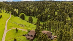 Une propriété rurale comprenant une grande maison, un petit chalet et un chemin sinueux.