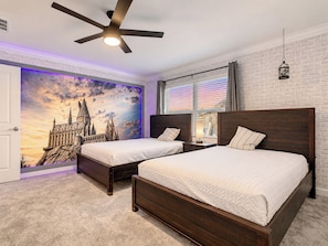 A bedroom with two beds, a ceiling fan, a brick wall, a window with blinds, and a wall mural. - Sunny Family Escape/ Private Pool & Themed Rooms (Kissimmee)
