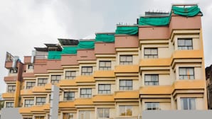 A multi-story building with a uniform facade, featuring balconies and windows. - Hotel Popular (Pune)