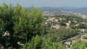 A residential area with houses surrounded by greenery and mountains in the background. - Studio with pool 5 minutes from Hyères beaches. Extraordinary view! (Hyères)