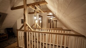 Eine Holztreppe mit weißer Geländer zu einem Dachboden.
