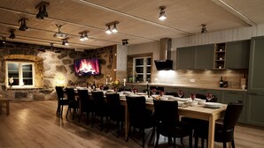 Ein Essbereich mit Steinwand, Holzboden und einem an der Wand befestigten Fernseher.