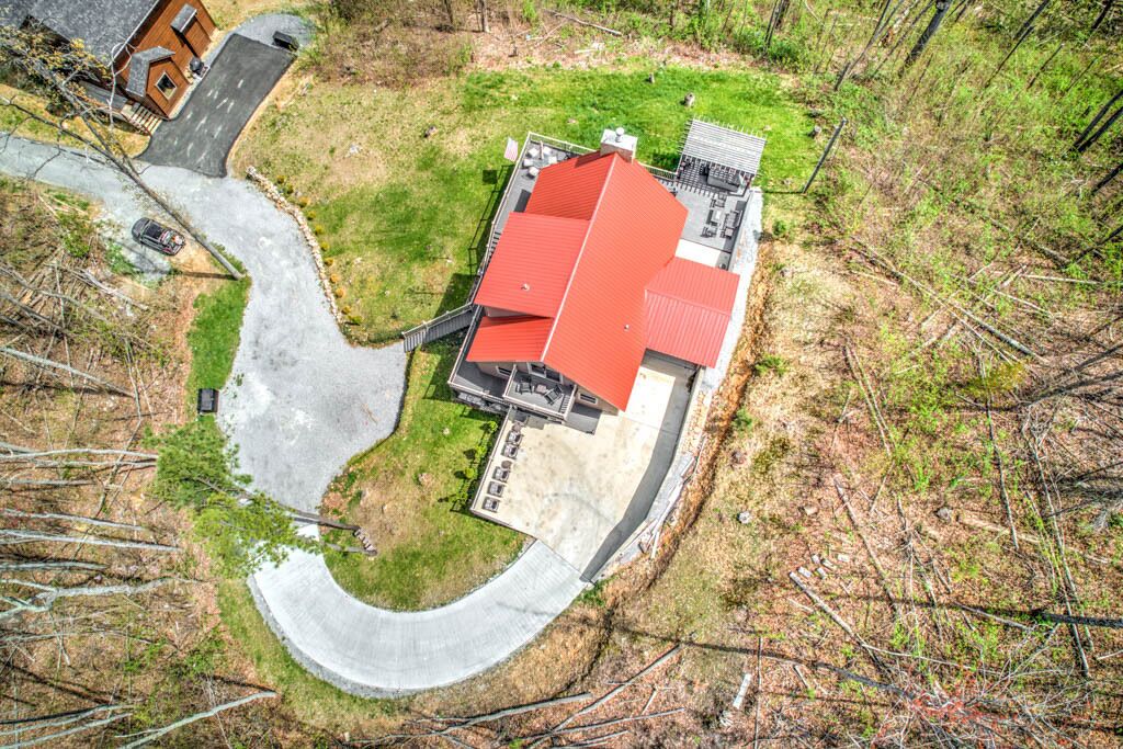 Une vue aérienne d’un bâtiment doté d’un toit rouge, entouré d’une allée sinueuse et d’espaces verts.