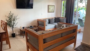 Una sala de estar moderna con un sofá de madera, una mesa de comedor y una planta en maceta.