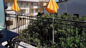 Un balcon avec des parasols jaunes, une table et des chaises.
