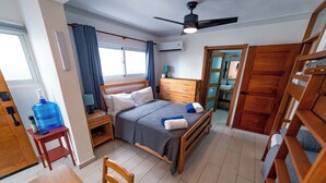 A bedroom with a bed, bedside table, and a large water dispenser.