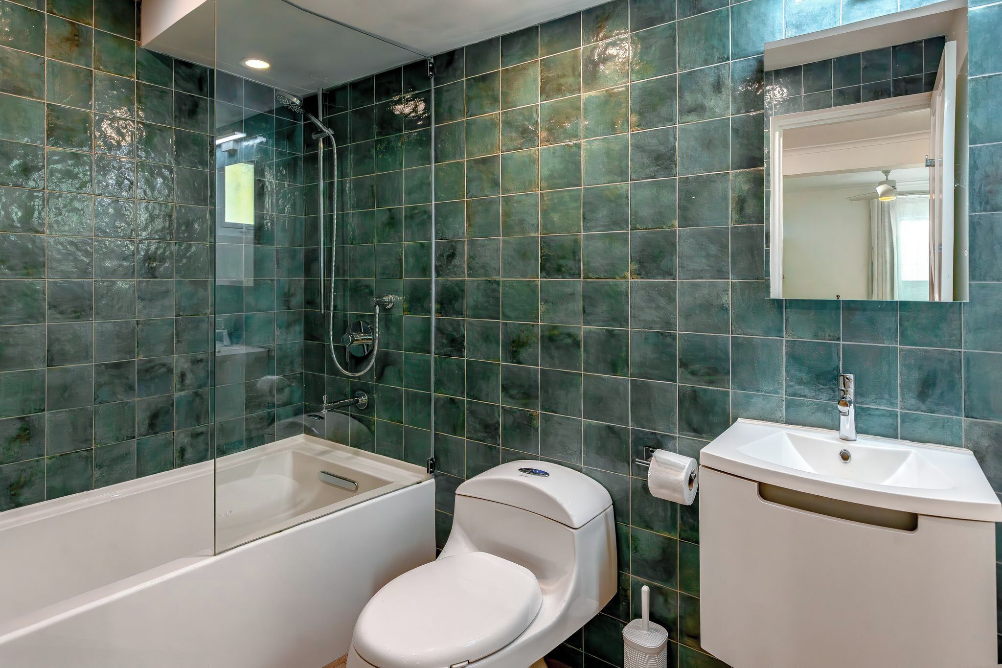 A bathroom with a bathtub, toilet, and sink.