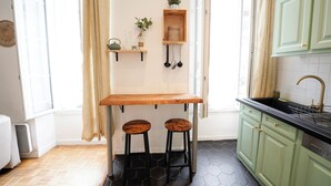 A kitchen with a wooden bar stool, a hanging plant, and a sink. - A break somewhere! (Marseille)