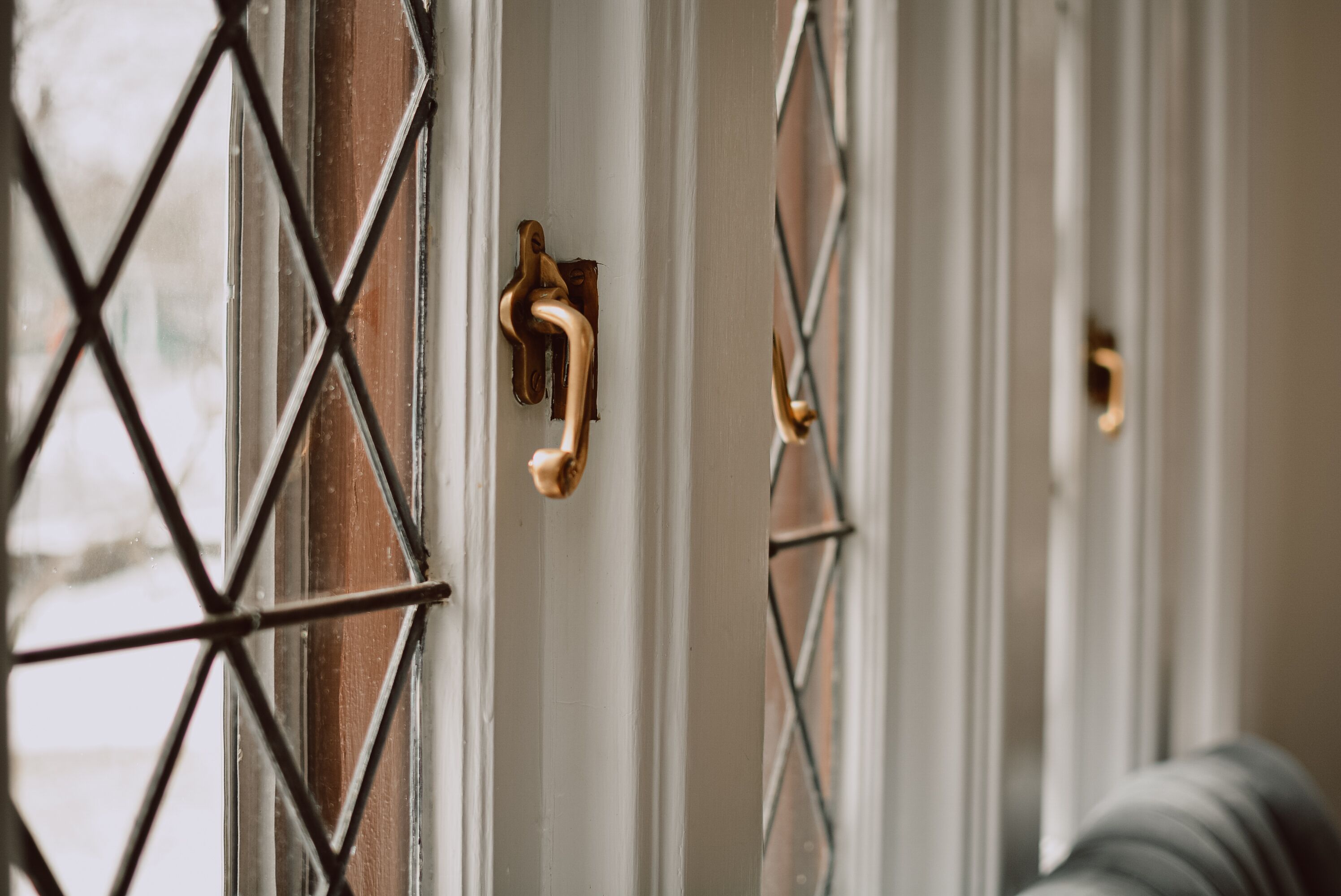 A door with a metal grid and a brass handle.