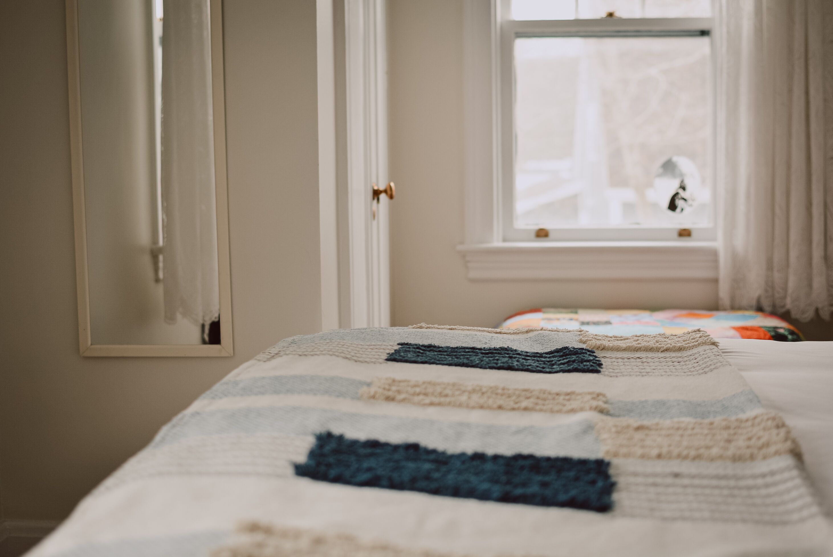Un dormitorio con cama, ventana y puerta.