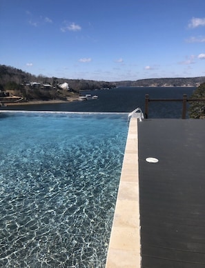 Relax by the serene pool, surrounded by a flat deck and tranquil views of the nearby water and shoreline.
