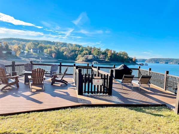 Relax on the deck with a serene view of the lake and surrounding landscape.