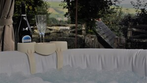A bottle of Prosecco and a glass on a table with a white tablecloth, set against a scenic outdoor backdrop. - Shepherd's hut with hot tub (Bodmin)