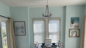 Ein Esszimmer mit Holztisch und Stühlen, einer Kristallleuchter und Kunstwerken an den Wänden.