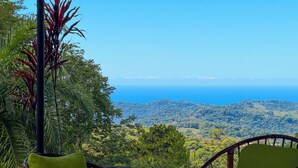 Una mesa y sillas con vista a un paisaje montañoso y al océano.
