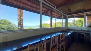 Una cocina con barra, ventanas amplias y vistas al exterior.
