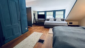 Een slaapkamer met een bed, een bureau en een televisie.