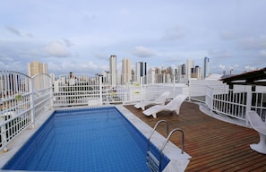 A rooftop pool with a city skyline view, white railings, and lounge chairs. - Incrível suíte em Manaíra por Carpediem (João Pessoa)