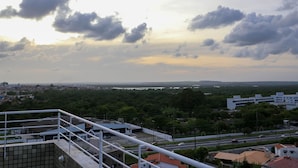 A view from a high vantage point overlooking a cityscape with buildings, roads, and a distant horizon. - Incrível suíte em Manaíra por Carpediem (João Pessoa)