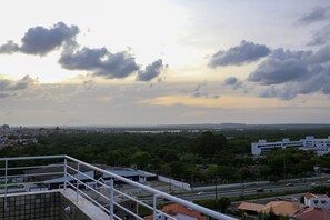 A view from a high vantage point overlooking a cityscape with buildings, roads, and a distant horizon. - Incrível suíte em Manaíra por Carpediem (João Pessoa)