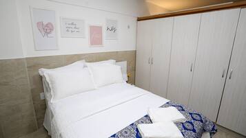 Un dormitorio con cama, armario y decoración en la pared.