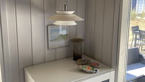 A room with a white console table, a hanging pendant light, a framed picture, and a vase. - Cozy cottage 250 m. from the beach. (Nykøbing sj.)