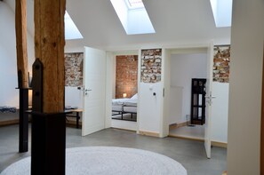 Experience a bright and airy loft-style living space with a cozy seating area and separate room.