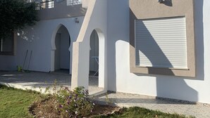 A modern building with a flat roof, large windows, and a garage door. - Villa (Gouvernement Medenine)