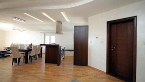 Een moderne keuken met een eethoek, houten vloeren en een inbouwoven.