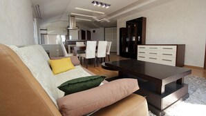 Een moderne woonkamer met een bank, salontafel en eethoek.