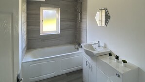 Une salle de bain moderne avec une baignoire, des toilettes et un lavabo.