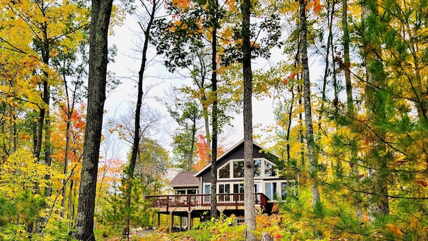 A cabin surrounded by autumn foliage. - Pet-Friendly Lakeside Cottage w/ Kayaks and Canoe! (Stone Lake)