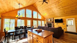 A spacious wooden cabin with a dining area, kitchen, and living room. - Pet-Friendly Lakeside Cottage w/ Kayaks and Canoe! (Stone Lake)