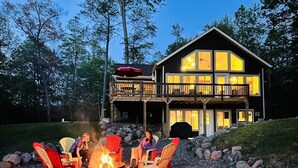 A lodge with a fire pit and outdoor seating. - Pet-Friendly Lakeside Cottage w/ Kayaks and Canoe! (Stone Lake)